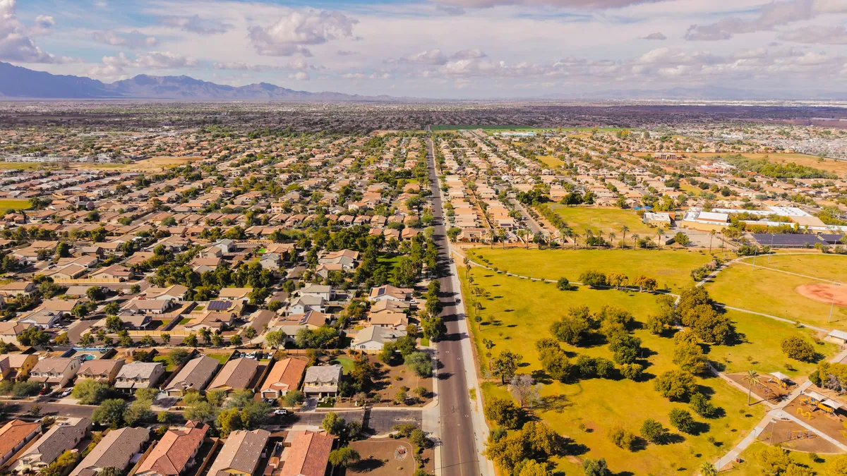 Aerial view of a desert suburban neighborhood with mountains on the horizon